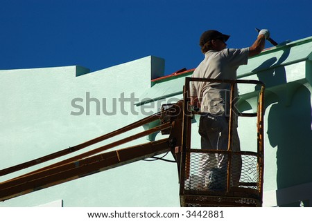 painter working on store front out of \