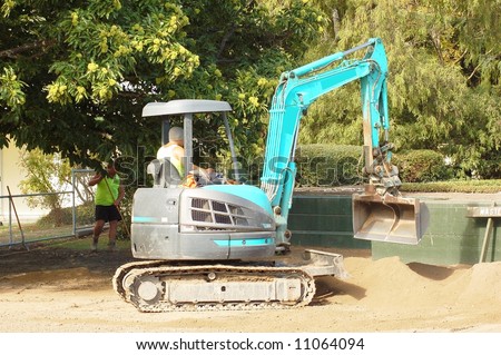 Small digger used to tidy garden in park
