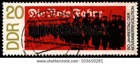 GERMANY - CIRCA 1968: A stamp printed in East Germany dedicated to the 50th Anniversary of the November Revolution shows armed sailors and workers struggling for peace, freedom and bread, circa 1968.