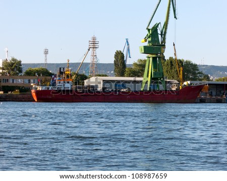 VARNA, BULGARIA - JULY 21: Cargo ship MUAZZEZ K, Flag: Turkey, Year Built: 1995, is loaded with goods on July 21, 2012 in Varna, Bulgaria.