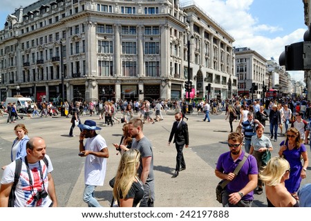 LONDON - JULY 1, 2014: People crossing at Oxford Circus in London. It\'s where the two busiest shopping street in London (Oxford and Regent St.) intersect and is visited by millions of people annually.