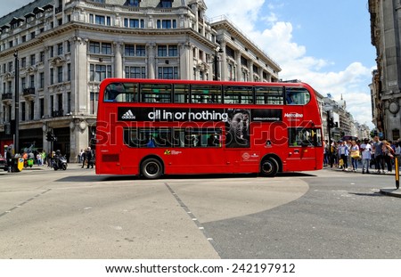 LONDON - JULY 1, 2014: A London red bus bearing Adidas advertisement crossing at Oxford Circus in London.