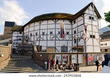LONDON - JULY 1, 2014. People passing by in front of posters advertising plays at The Globe Theater. The theater is a reconstruction of Shakespeare\'s original globe, opened for performances in 1997.