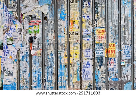 VARNA, Bulgaria, FEB 07, 2015: Urban background old fence with torn papers advertising various event, including elections and concerts.