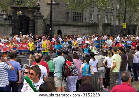 The crowd is saluting, cheering and applauding the marathon runners in London.