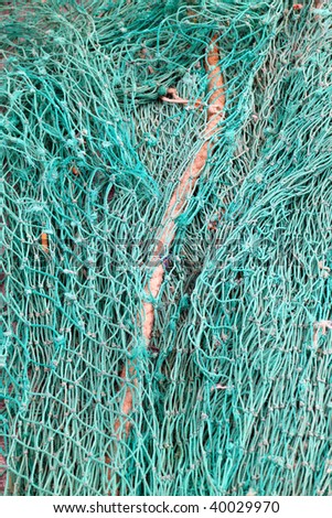Detail of fishing nets stacked in a heap on the quayside - useful background or texture