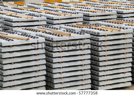 Concrete railway sleepers piled in a factory yard