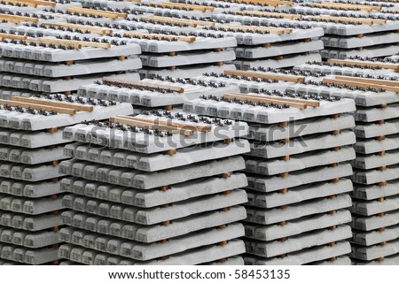 Concrete railway sleepers piled in a factory yard