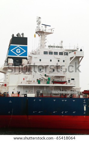VARNA, BULGARIA - NOVEMBER 17: Cargo ship GENCO OCEAN (IMO: 9450739) is assisted by three tugboats on November 17, 2010 in Varna, Bulgaria. She is the newest ship to visit Port of Varna this year.