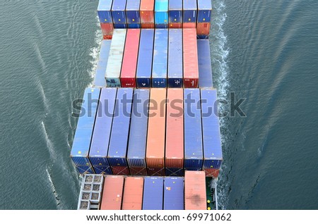 VARNA, BULGARIA - JANUARY 20: Cargo ship DS BLUE OCEAN (Flag: United Kingdom, IMO: 9341976) sails into open sea on January 20, 2011 in Varna, Bulgaria. Containers on board the ship seen from above.