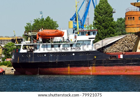 VARNA, BULGARIA - JUNE 24: Cargo ship SEA-ANGEL (Built: 1970, Flag: Comoros) is loaded with 2800 t of logs in Port of Varna-East on June 24, 2011 in Varna, Bulgaria.