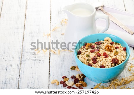 oatmeal with nuts and dried fruits on old white painted wooden table. Perfect breakfast