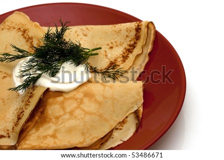 pancakes with filling on red shining plate