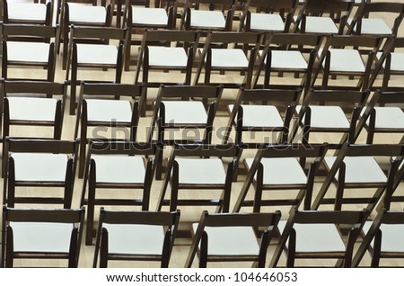 Symmetry of folding chairs before indoor wedding ceremony