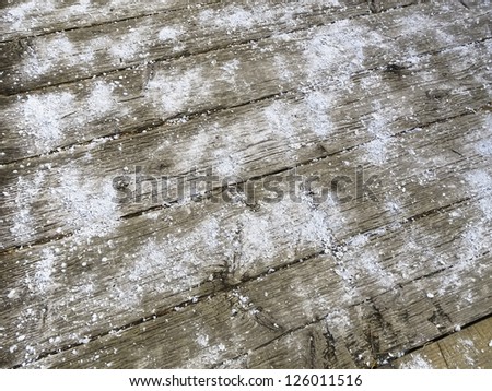Safety precaution in winter: Rock salt on wooden planks of pedestrian bridge in public park, Woodridge, Illinois