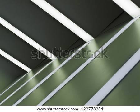 Interior abstract: Ceiling lights and white stripes on green wall at auto show