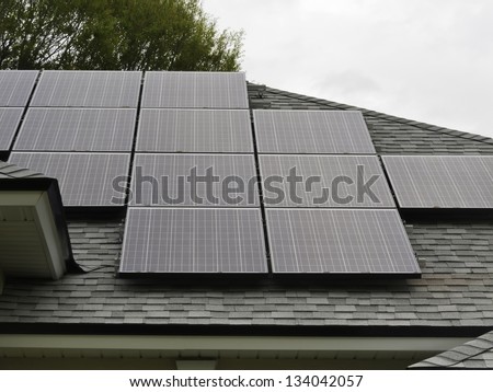 Solar panels on sloped roof of house on overcast day
