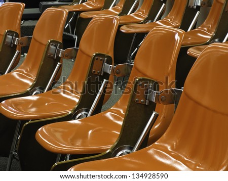 One size fits all: Identical shiny hard orange molded seats in lecture hall
