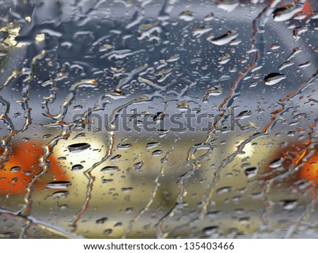 Rainy windshield (shallow depth of field) in morning rush hour