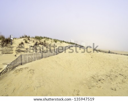 Coastal mirage: High-rises beyond sand dunes partially obscured by morning fog moving in from the Atlantic Ocean south of Virginia Beach, Virginia