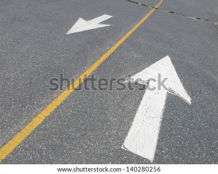 White arrows pointing in opposite directions on street