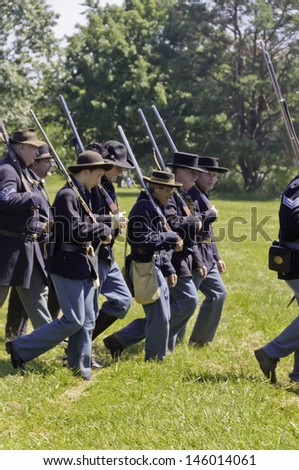 WAUCONDA, ILLINOIS/USA - JULY 13: American Civil War (1861-1865) reenactment on July 13, 2013, in Wauconda, Illinois. Confederate troops of various ages march with muskets across mock battlefield.