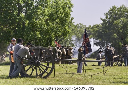 WAUCONDA, ILLINOIS/USA - JULY 13: American Civil War (1861-1865) reenactment on July 13, 2013, in Wauconda, Illinois. Boy-actor holds Confederate flag near munitions wagon on mock battlefield.
