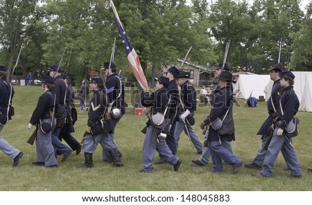 LOMBARD, ILLINOIS/USA - JULY 27: American Civil War (1861-1865) reenactment on July 27, 2013, in Lombard, IL. Teenage and adult actors dressed as Union soldiers march from encampment toward battle.