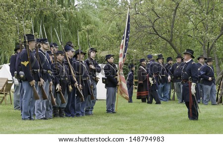 LOMBARD, ILLINOIS/USA - JULY 27: American Civil War (1861-1865) reenactment on July 27, 2013, in Lombard, IL. Union officer reviews infantry troops at encampment before they march to a mock battle.