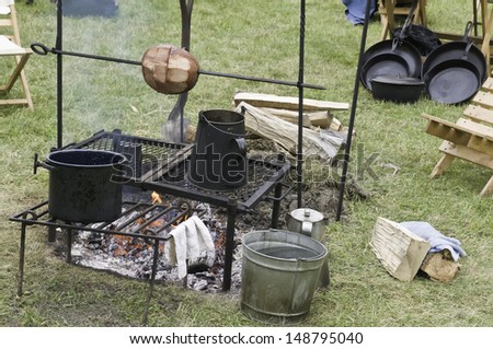 Meat (minus a few slices) roasting on spit over campfire in Confederate camp at a reenactment of the American Civil War (1861-1865)