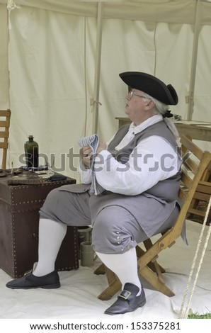 WHEATON, ILLINOIS/USA - SEPTEMBER 7: American Revolutionary War (1775-1783) reenactment on September 7, 2013, in Wheaton, IL. Actor portrays Benjamin Franklin  in a small tent in military encampment.