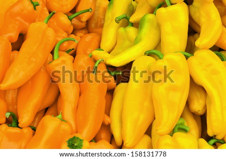 Red and yellow banana peppers with green stems at farmer\'s market in Oregon