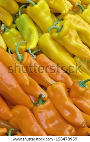 Shiny red and yellow banana peppers with green stems at farmer\'s market in Oregon
