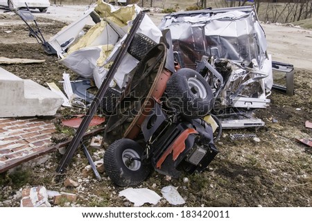 WASHINGTON, ILLINOIS, USA - MARCH 21, 2014: Large debris, including this overturned ride-on mower, remains in many ruined yards after a tornado wreaked havoc in the area on November 17, 2013.