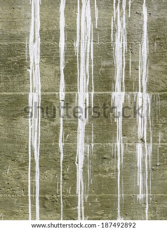 Gravity on a farm: Exterior wall of outbuilding with white paint streaks from wood higher up