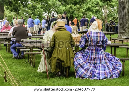 WAUCONDA, ILLINOIS/USA - JULY 12, 2014: Actors in period dress eat lunch and listen to discussion by Confederate and Union officers in a reenactment of the American Civil War (1861-1865).