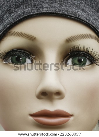 Closeup of round face of expressionless young female mannequin scarecrow with gooey eyes at a fall festival