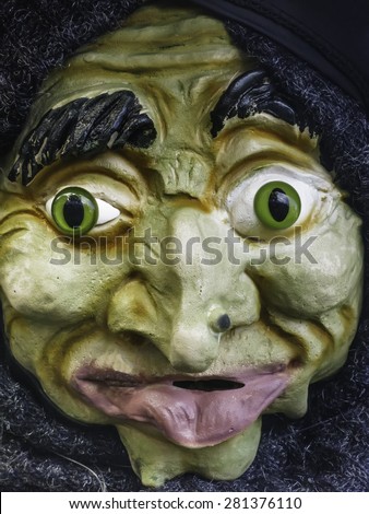 Closeup of grotesque Halloween goblin or gnome with green eyes and large lower lip
