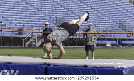 PARK RIDGE, ILLINOIS, USA - July 23, 2015: A senior high jumper clears a horizontal bar  in the Six-County Senior Games, held by the Illinois Park and Recreation Association, on a summer morning.