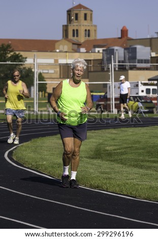PARK RIDGE, ILLINOIS, USA - July 23, 2015: Two seniors, a woman and a man, run a mile-long race in the Six-County Senior Games, held by the Illinois Park & Recreation Association, on a summer morning.