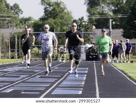 PARK RIDGE, ILLINOIS, USA - July 23, 2015: Four senior sprinters compete in a heat of the 50-meter dash in the Six-County Senior Games, sponsored by the Illinois Park and Recreation Association.