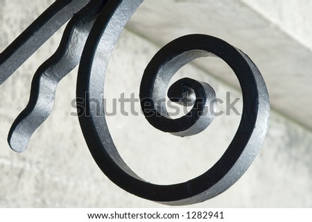 Curlicue in wrought iron railing with blurred background