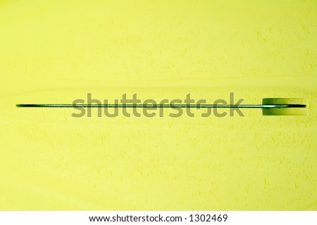 Rudder of yellow racing boat with raindrops on hull