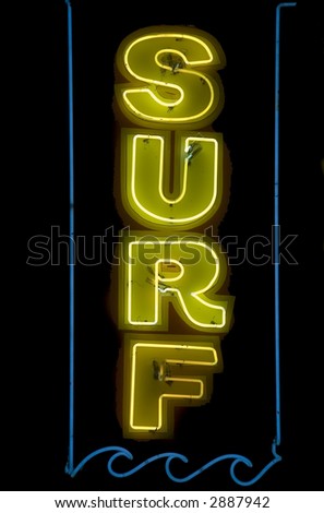 Neon sign -- SURF -- in capital letters at night over beach shop in tourist town