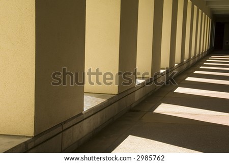Interplay of sunlight and shadow along passageway outside university building