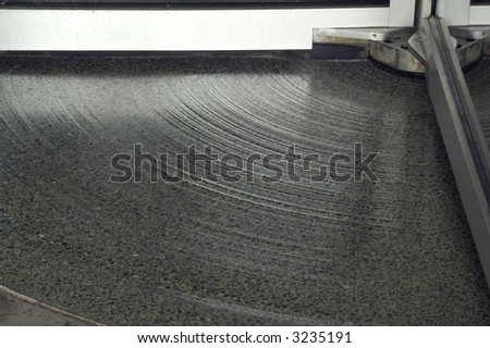 Section of grooved floor beneath revolving door