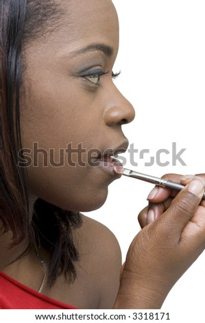 stock photo Profile of young black woman touching up her lips with a 