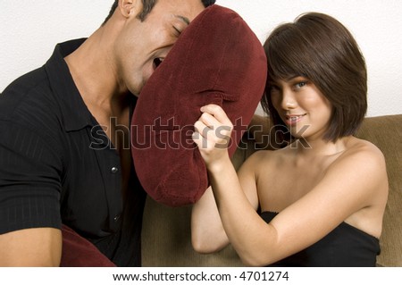 Pretty young Asian-American woman uses pillow to fend off older Latin lover