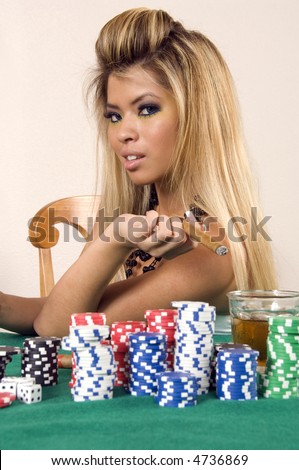 Pretty young Asian-American woman holds cigar  by stacks of poker chips and drink