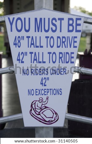 Height-requirement sign outside carnival ride